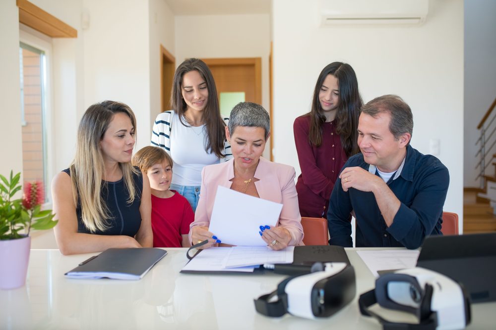 Greater Love and Care care professional reviewing a care plan with a multi-generational family at home